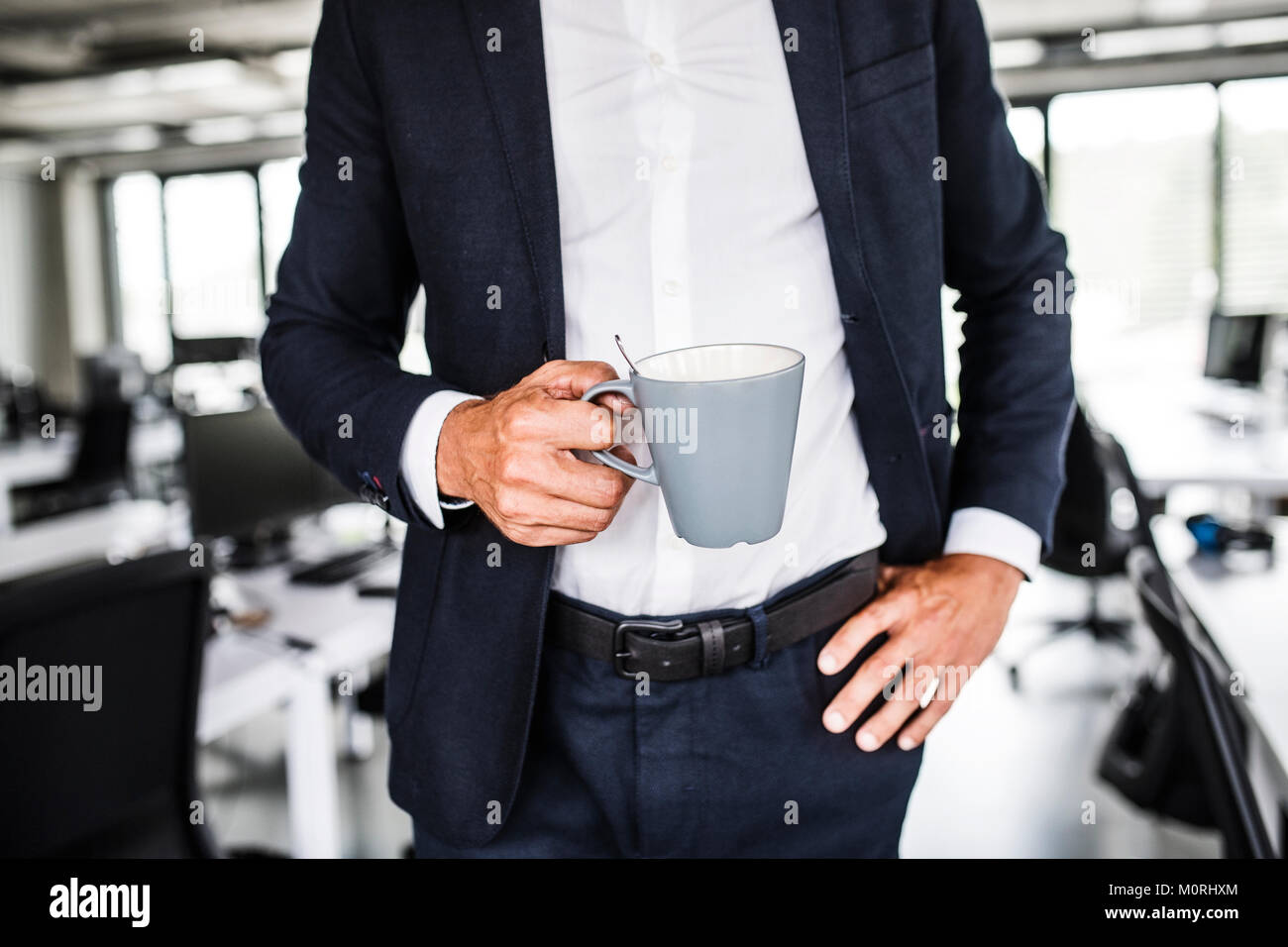 Close-up di imprenditore tenendo tazza da caffè in ufficio Foto Stock