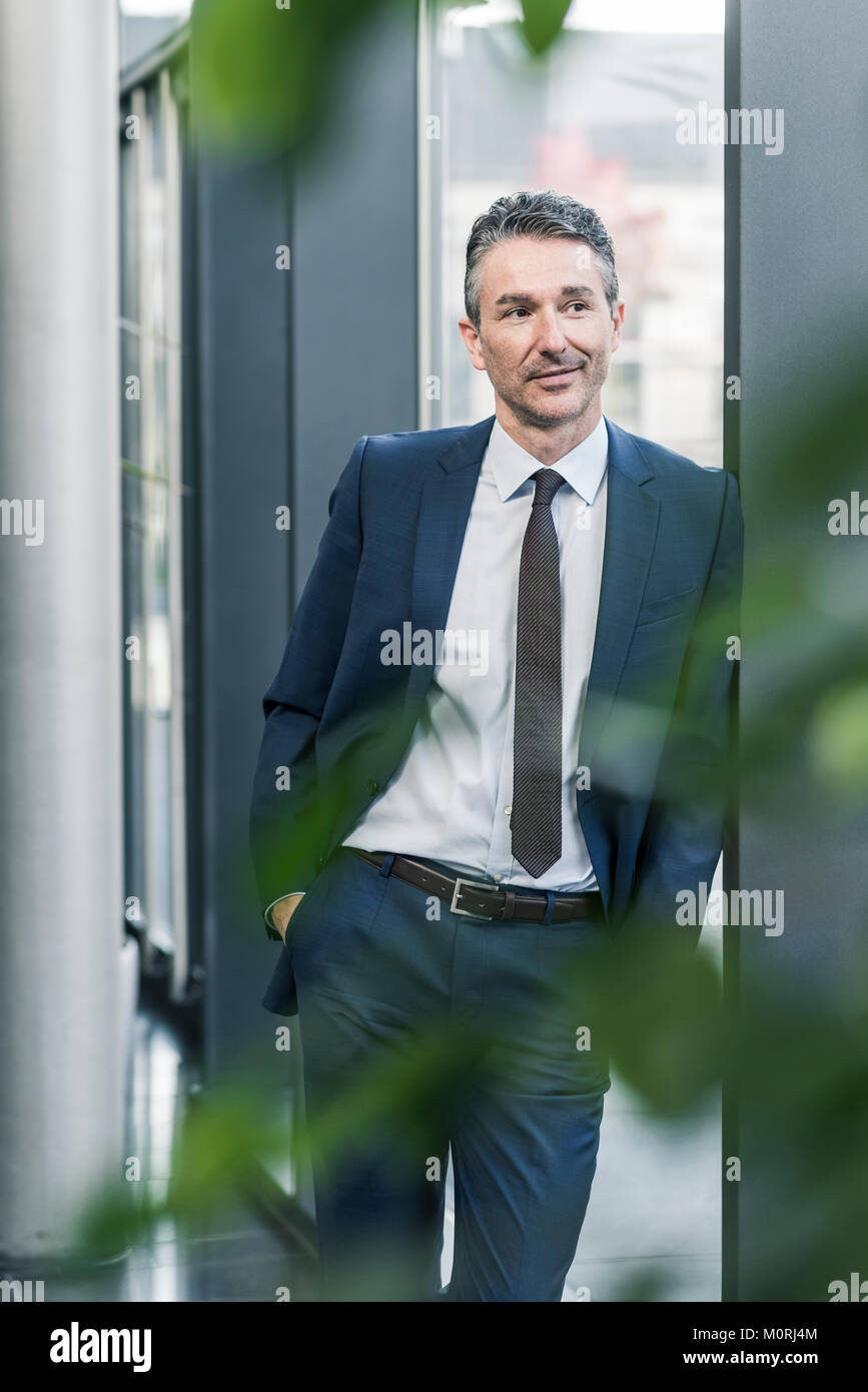 Imprenditore in piedi nella lobby di office Foto Stock