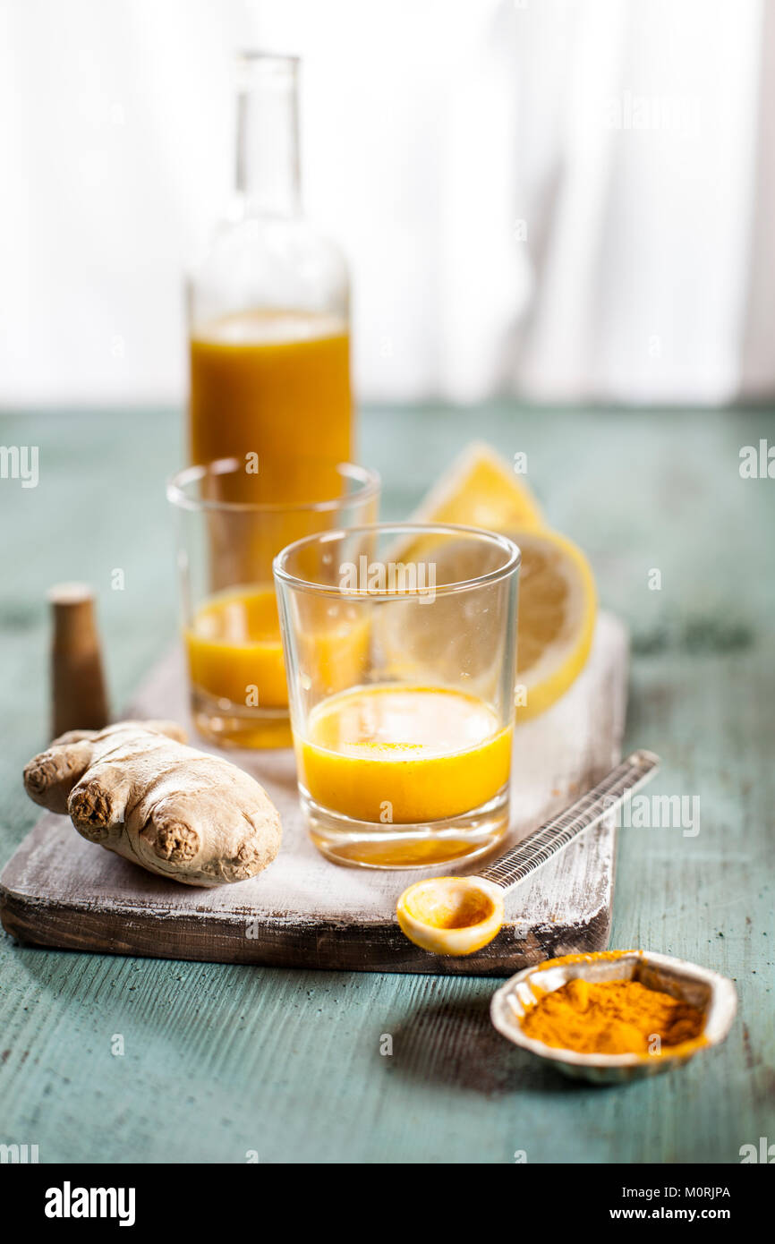 Detox drink, zenzero, limone e arancia con curcuma e peperoncino in polvere Foto Stock