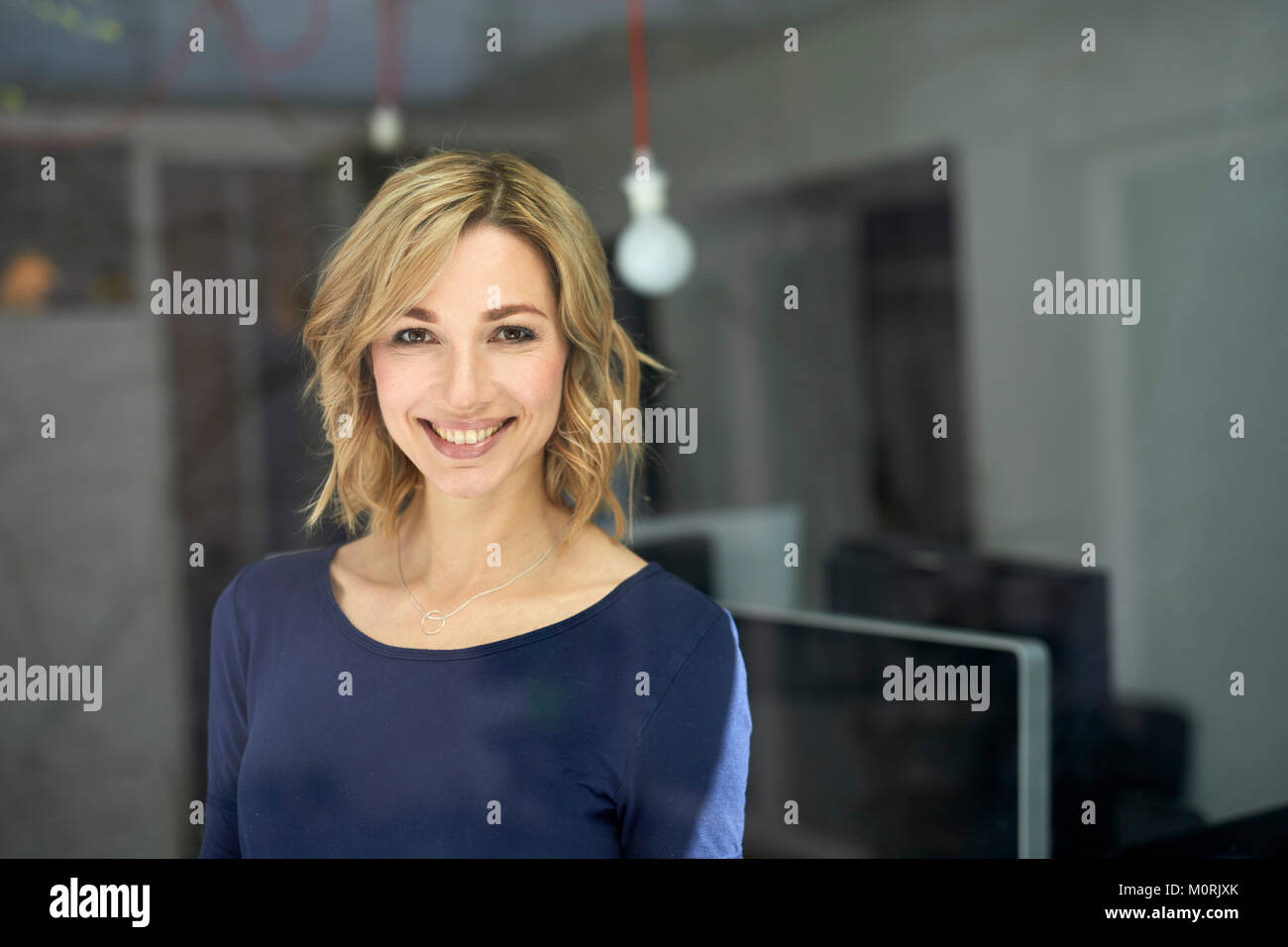 Ritratto di donna bionda dietro il vetro Foto Stock