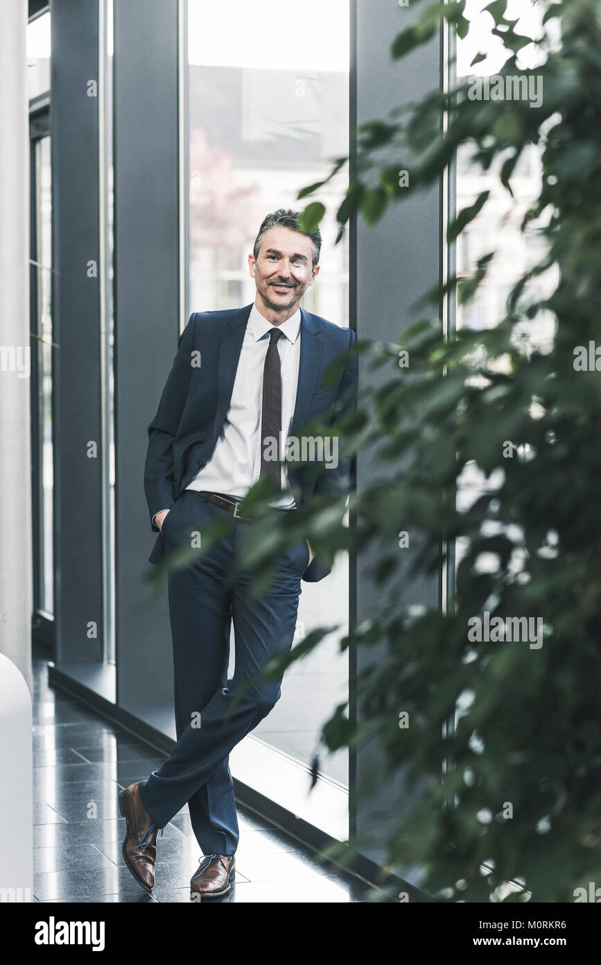 Ritratto di imprenditore sorridente in piedi nella lobby di office Foto Stock
