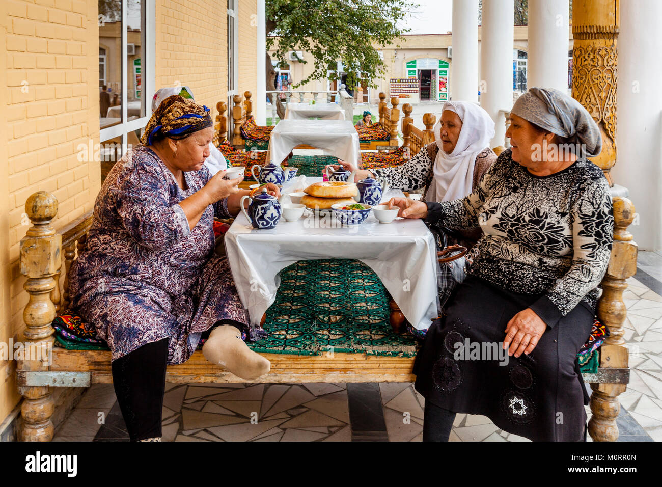 Un piccolo gruppo di donne uzbeke di mangiare il pranzo presso una caffetteria all'interno del Bazaar Principale, Samarcanda, Uzbekistan Foto Stock