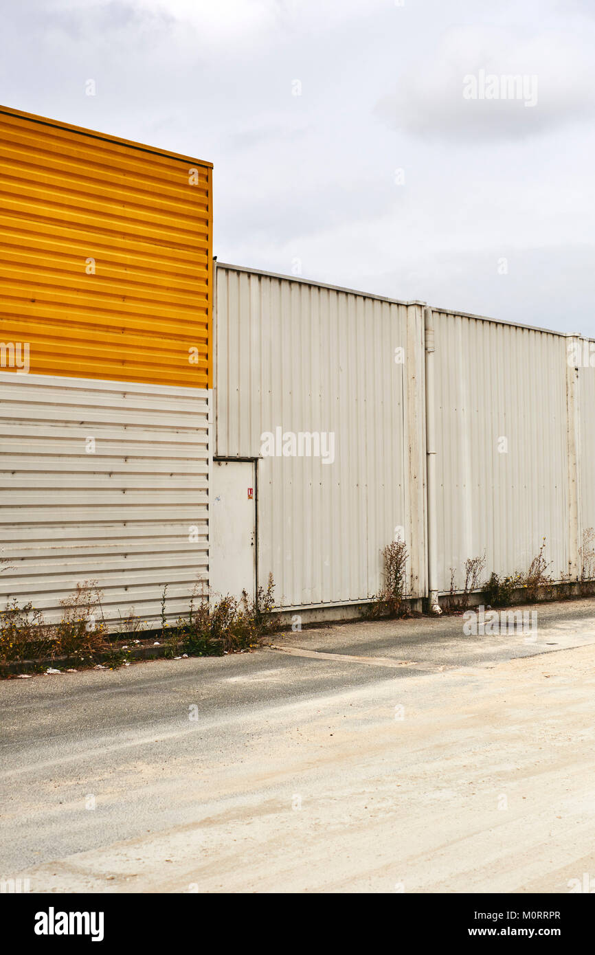 Abbandonato il magazzino vuoto con giallo / arancio pannellatura. Foto Stock