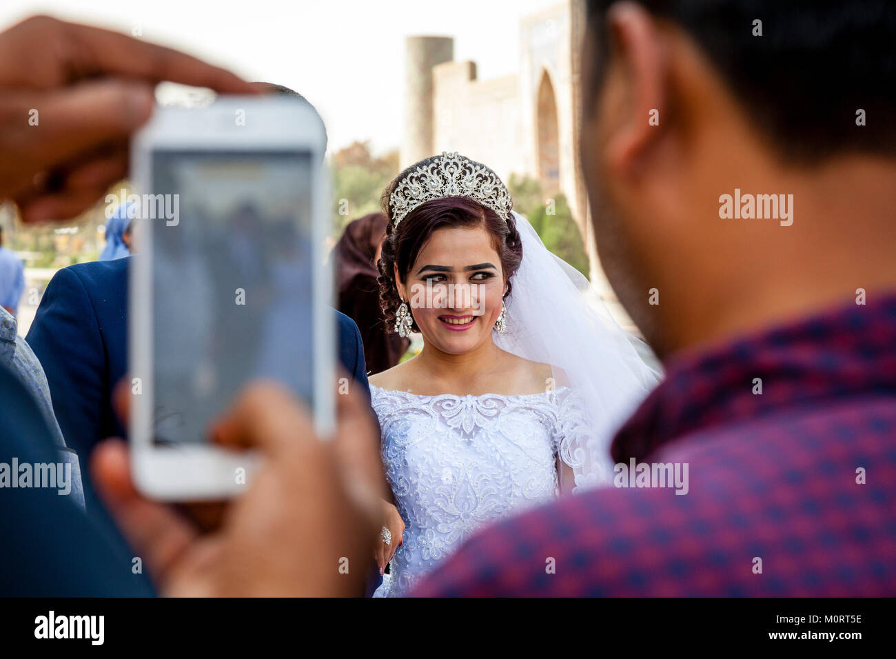 I turisti scattare delle foto di un 'Just Married " Coppia Giovane presso il Complesso Registan, Samarcanda, Uzbekistan Foto Stock