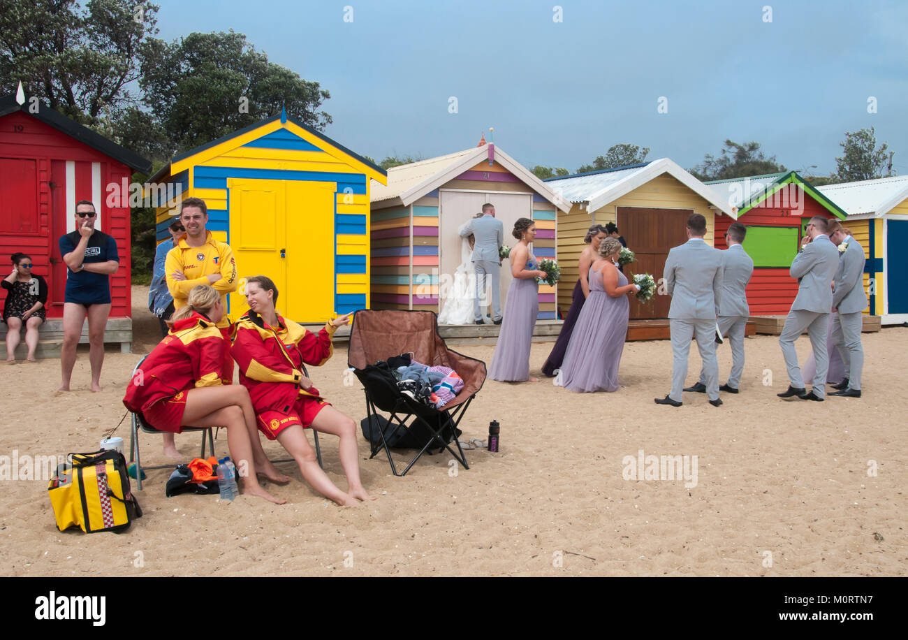 Lifesavers sulla strada Dendy Spiaggia di Brighton sono distratti da un party di nozze, che posano per una foto riprese, Melbourne, Australia Foto Stock