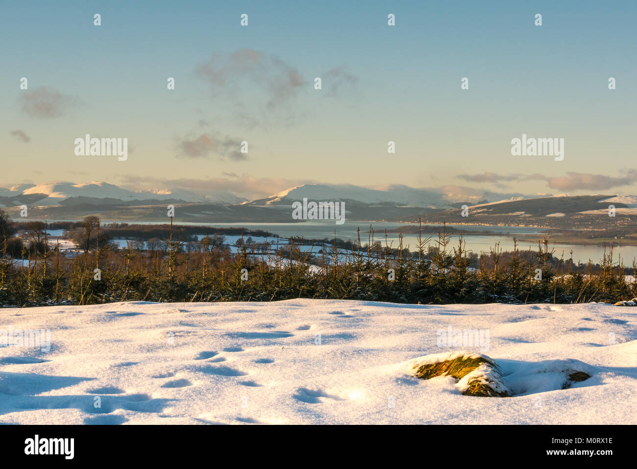 Scena invernale del fiume Clyde dalla collina sopra Langbank, con montagne coperte di neve, cielo blu e acque calme nella luce della sera, Strathclyde, Scozia, Regno Unito Foto Stock