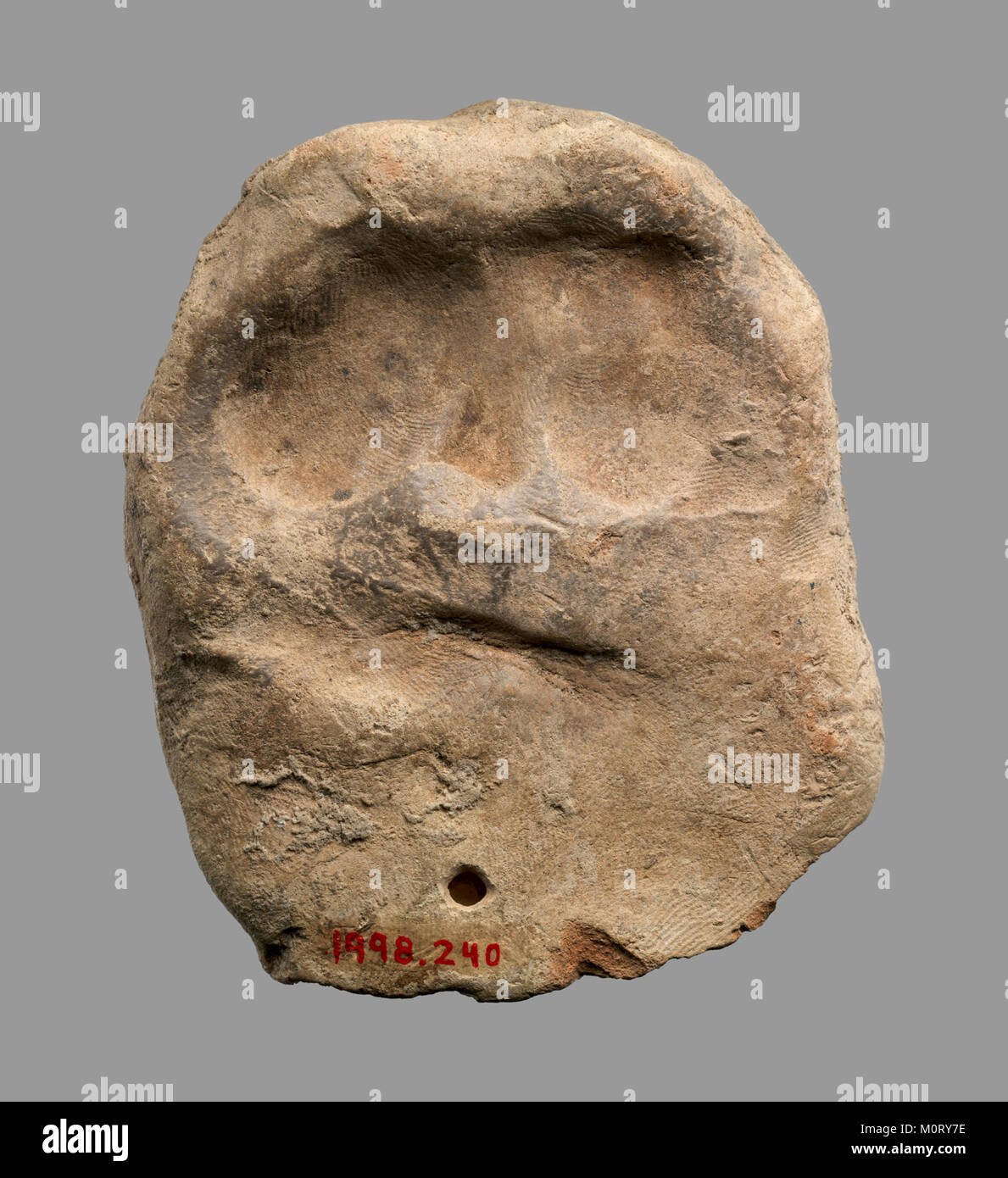 Questo pezzo in ceramica, simile a un rullo in bronzo, presenta due personaggi vestiti in kilt. Fa parte di un'antica collezione che illustra tecniche artistiche e simbolismo culturale attraverso l'imitazione in ceramica e bronzo. Foto Stock