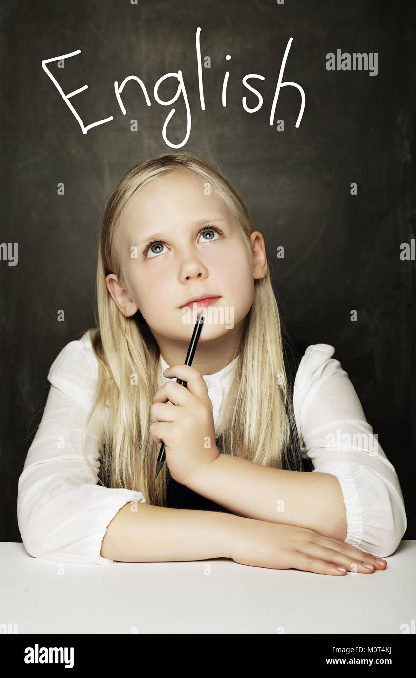 Femmina Scuola Primaria apprendimento dello studente inglese sull'aula scolastica sfondo Blackboard Foto Stock