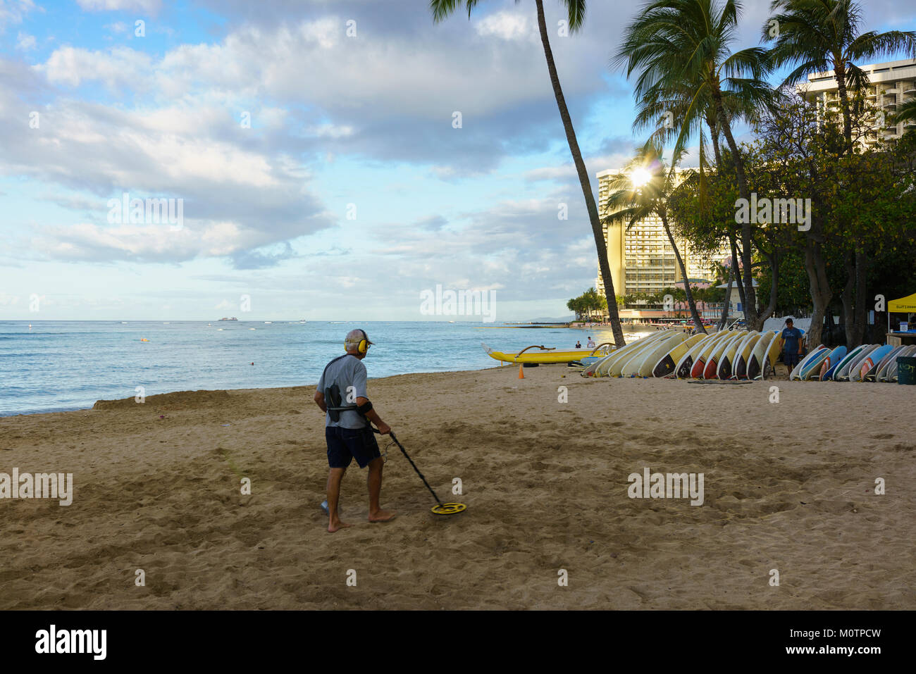 Uomo con rilevatore di metalli sulla spiaggia di Waikiki Beach Foto Stock