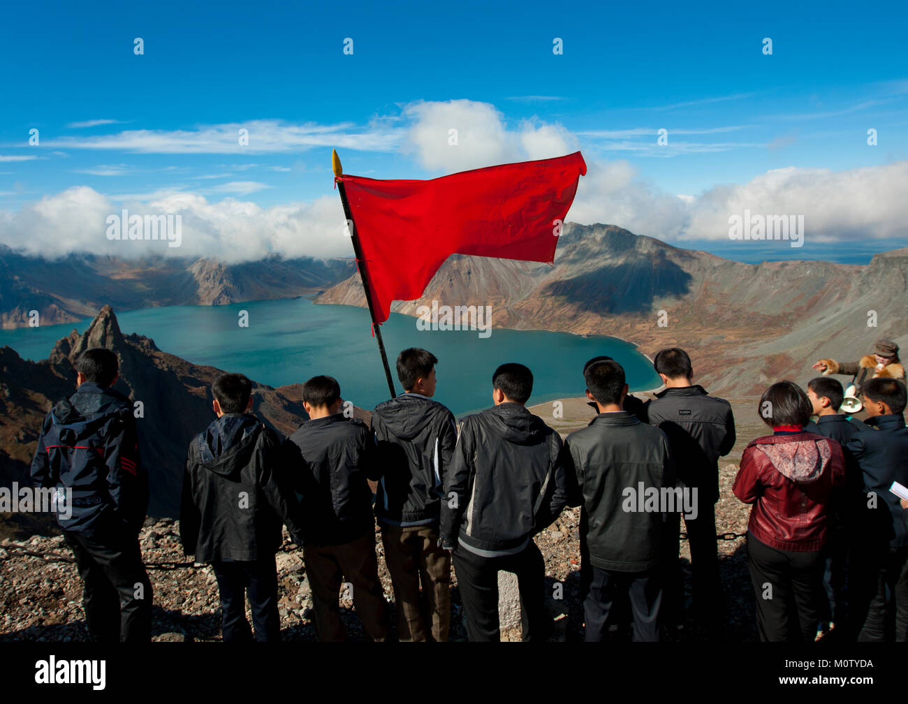Gruppo di studenti con bandiera rossa nella parte anteriore del lago a monte Paektu, Ryanggang Provincia, Mount Paektu, Corea del Nord Foto Stock