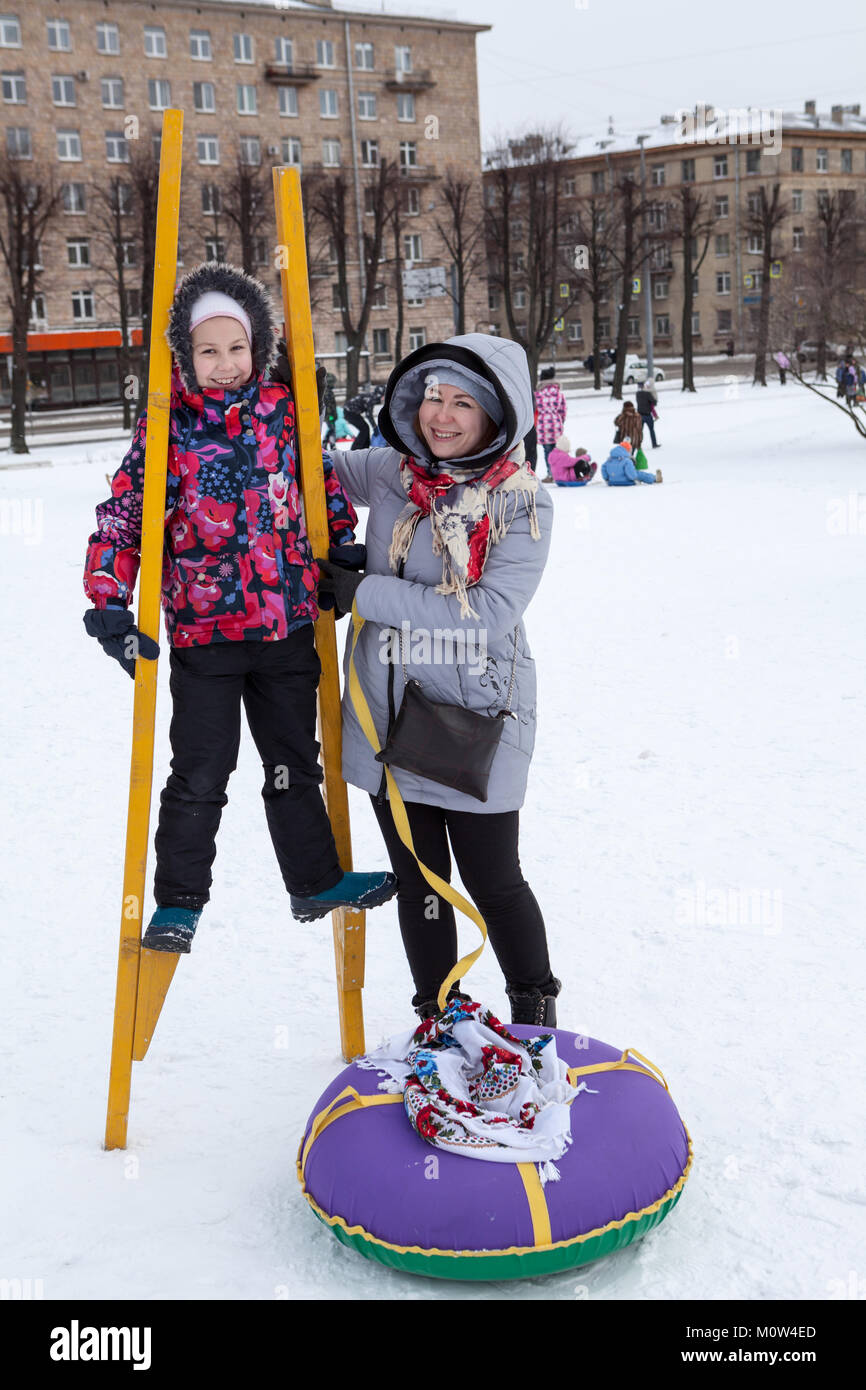 Felice e soddisfatto la madre e il bambino provare a camminare su palafitte in inverno. Attività sociali sono in vacanza Maslenitsa Foto Stock