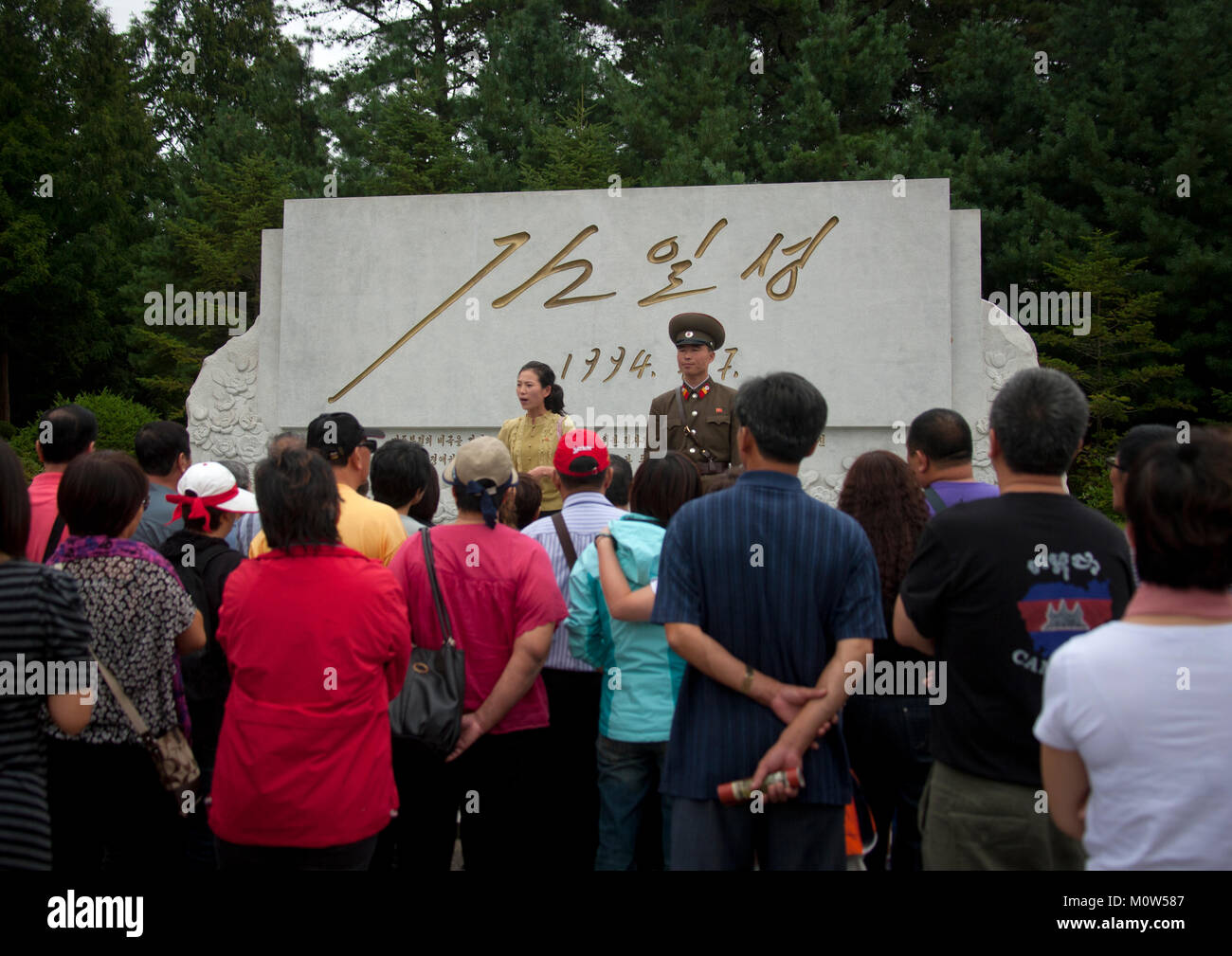 Corea del Nord guida tour con un gruppo di turisti davanti a un monumento con la firma di Kim il Sung, Nord provincia Hwanghae, Panmunjom, Corea del Nord Foto Stock