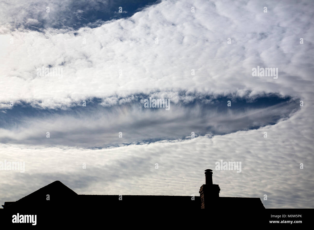 Immagine di rara Fallstreak fori formati in cirrocumulus altocumulus e nuvole nel Wiltshire. Foto Stock