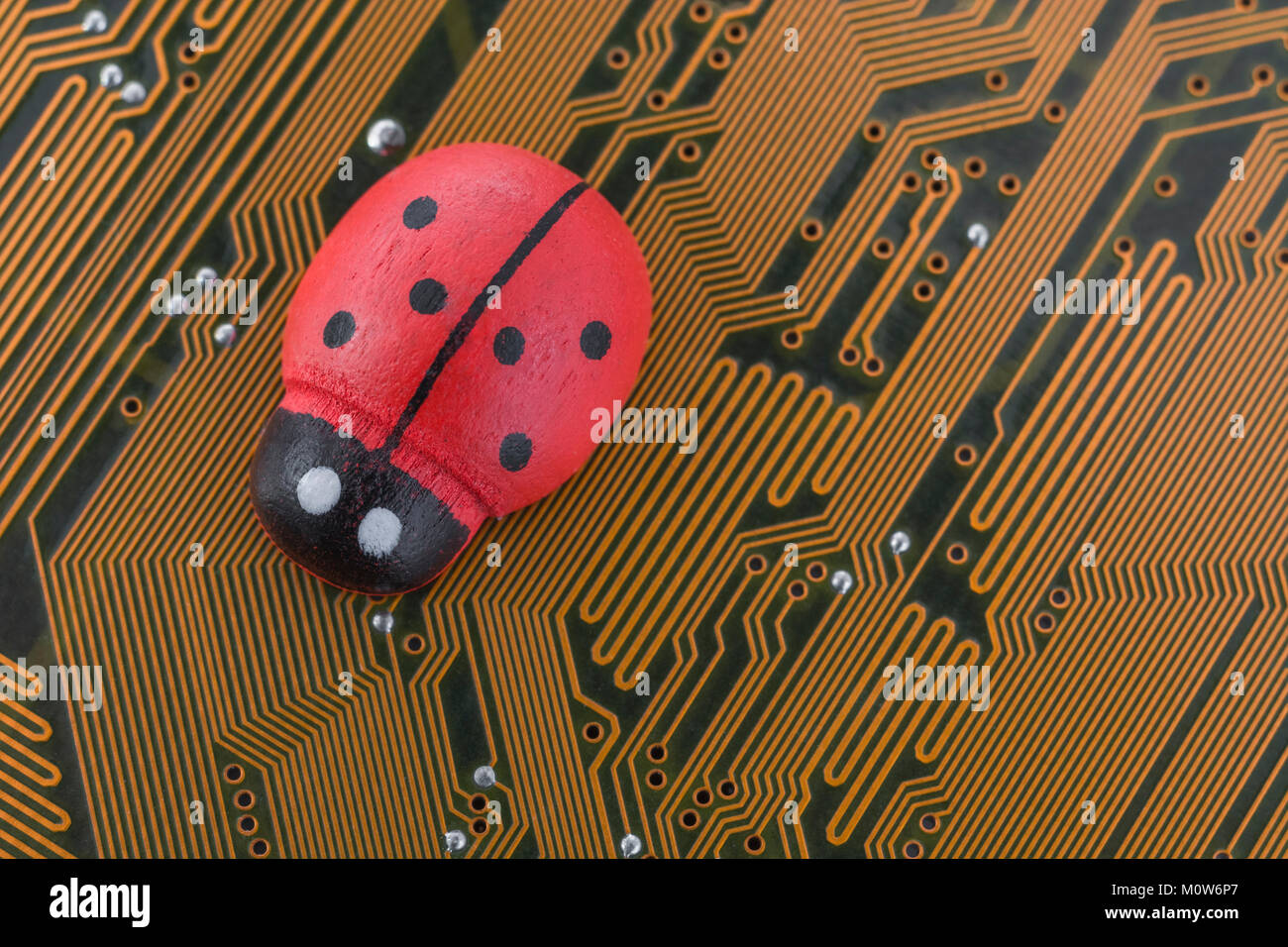 Piccolo giocattolo coccinella - come metafora visiva per il concetto di computer bug, errori di software, hardware di bug, virus informatici. Foto Stock