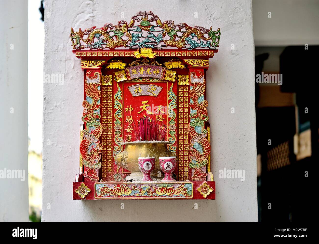Cinese tradizionale strada buddista santuario appeso al di fuori di un negozio Casa di Geylang, Singapore Foto Stock