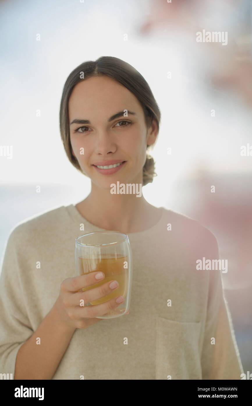 Ritratto sorridente brunette donna di bere succo di frutta Foto Stock