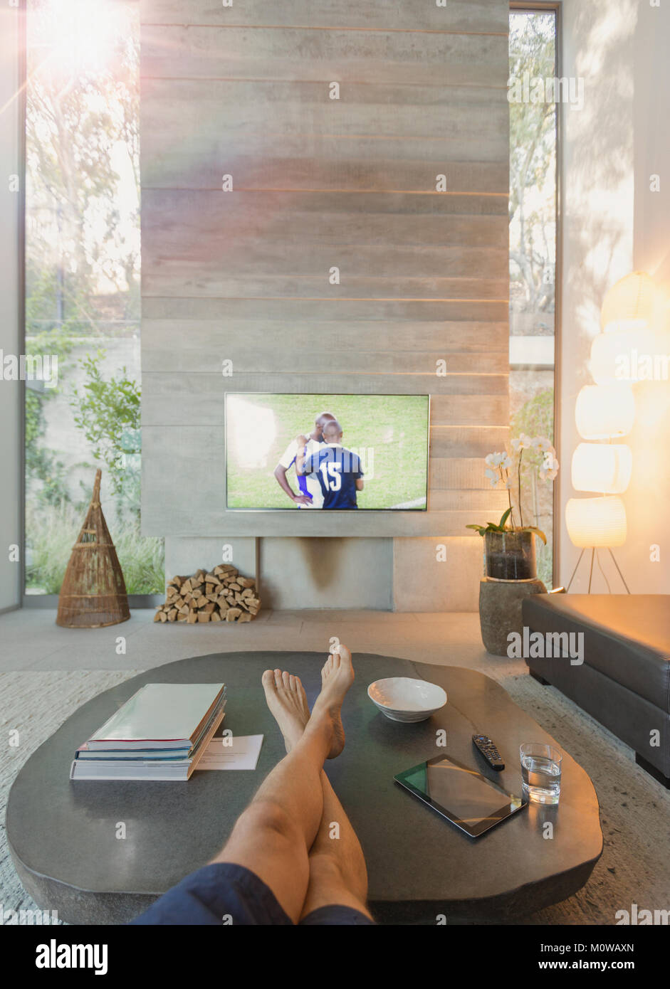 Personale prospettiva uomo guardare partite di calcio in TV in soggiorno Foto Stock