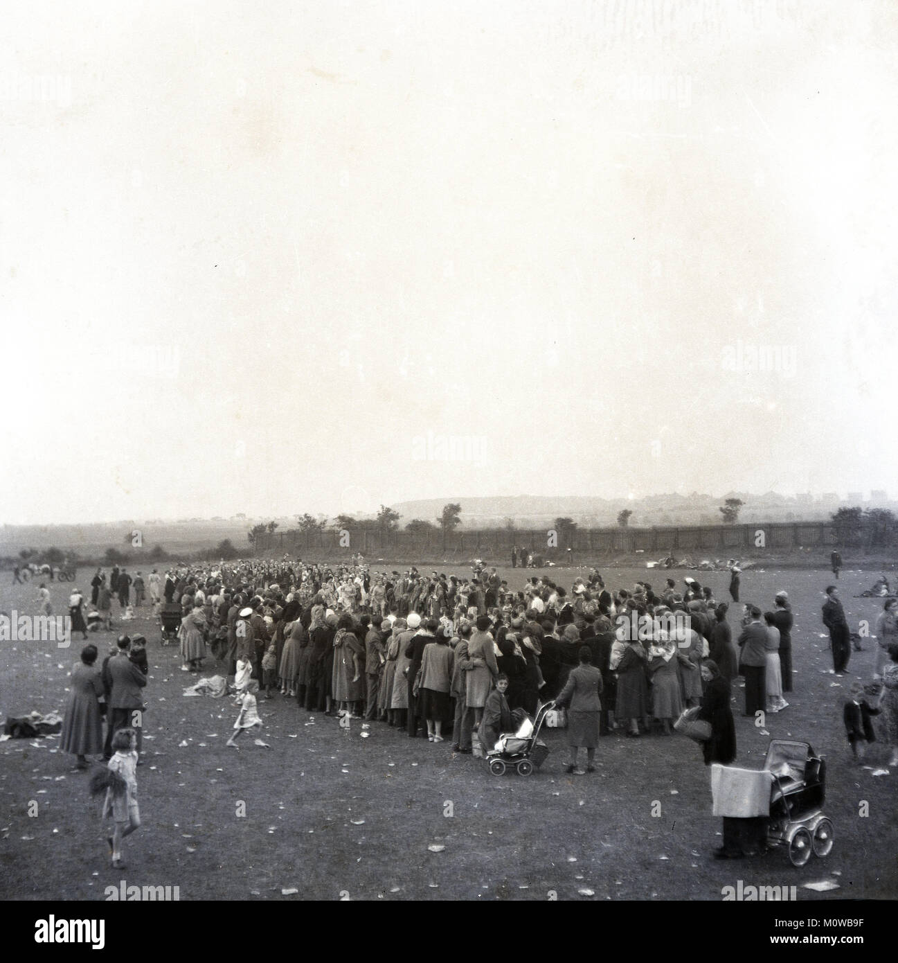 1951, storico, una atmosfera di carnevale come spettatori circondano un piccolo gruppo di donne che prendono parte a una gara di corsa o dash al di fuori di un campo durante le celebrazioni per la festa della Gran Bretagna, Inghilterra, Regno Unito. Foto Stock