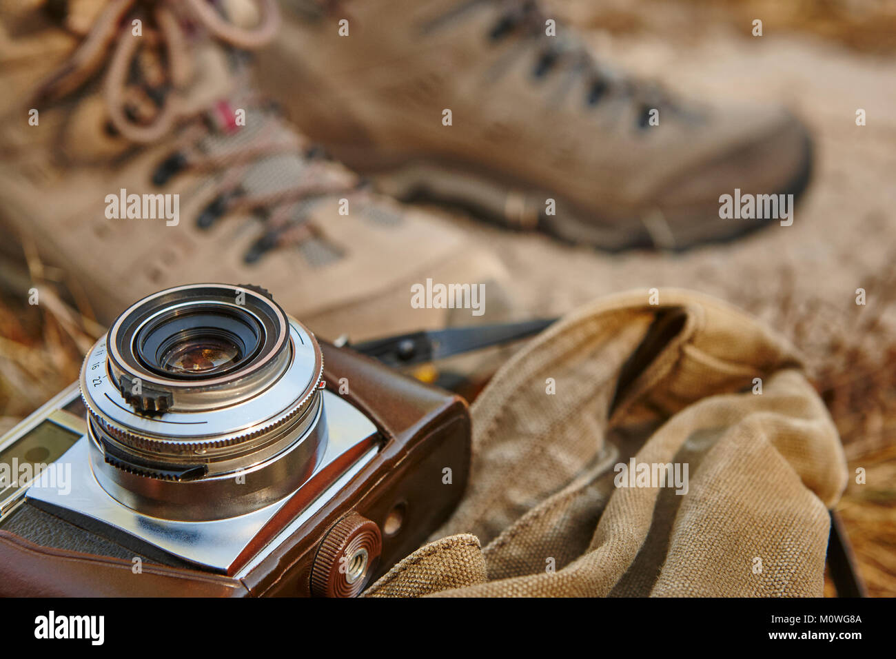 Vintage fotocamera con scarpe da trekking sulla terra. Sfondo di viaggio Foto Stock