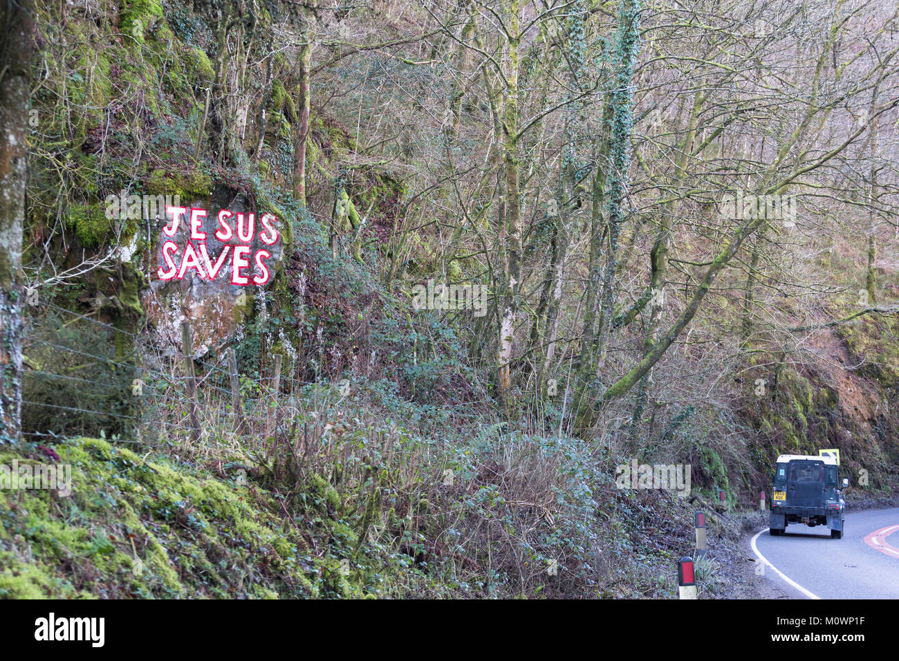 Gesù salva scritto in vernice su una roccia accanto alla A484 tra Bronwydd bracci e Cynwyl Elfed, Carmarthenshire, Galles Foto Stock
