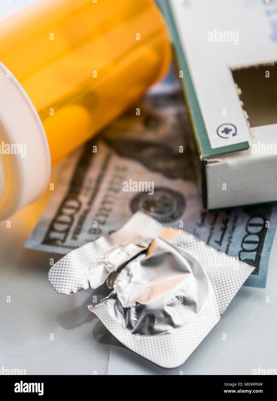 Alcuni medicinali accanto a un blocco di biglietti del dollaro, immagine concettuale Foto Stock