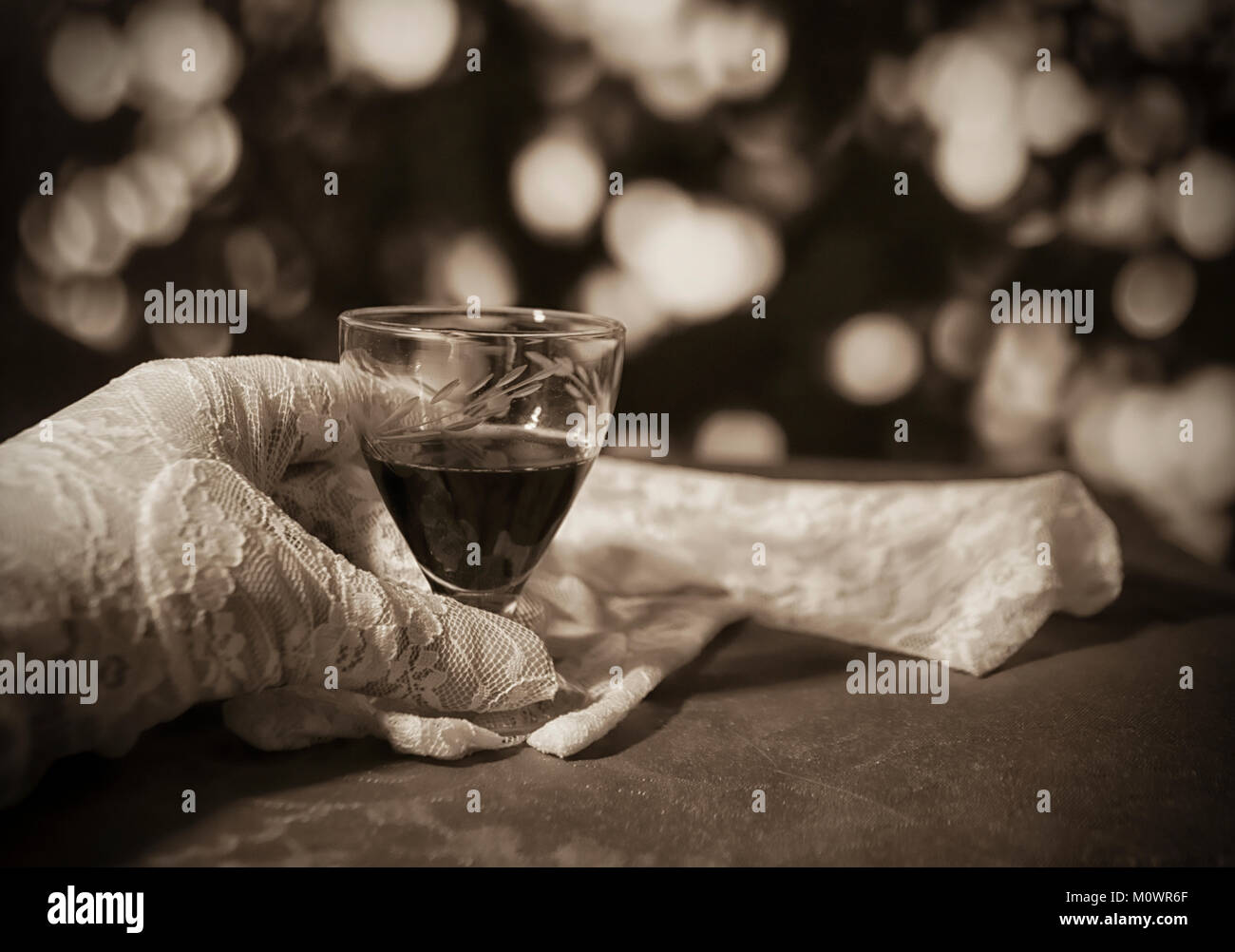 Bianco guanti di pizzo e un bicchiere di cherry brandy Foto Stock