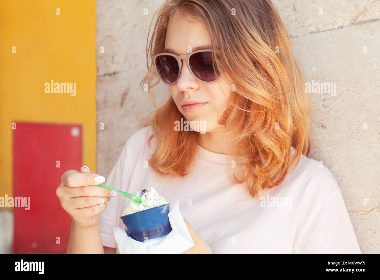 Europeo teenage girl in occhiali da sole mangia frutta gelato, close-up ritratto all'aperto Foto Stock