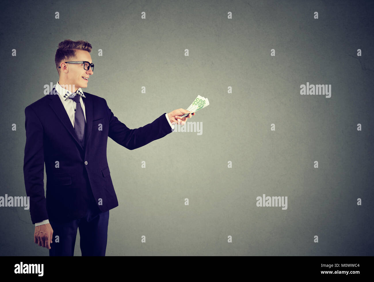 Giovane imprenditore fiducioso dare denaro in cerca di credito contenuto. Foto Stock