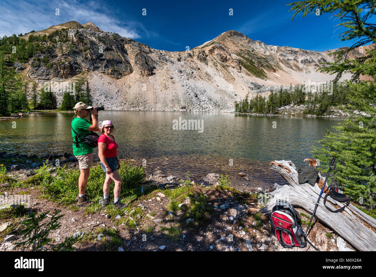Persone di mezza età gli escursionisti a minore Brewer Lago, Mount Brewer in distanza, Purcell montagne, Kootenay Rockies, vicino Invermere, British Columbia, Canada Foto Stock