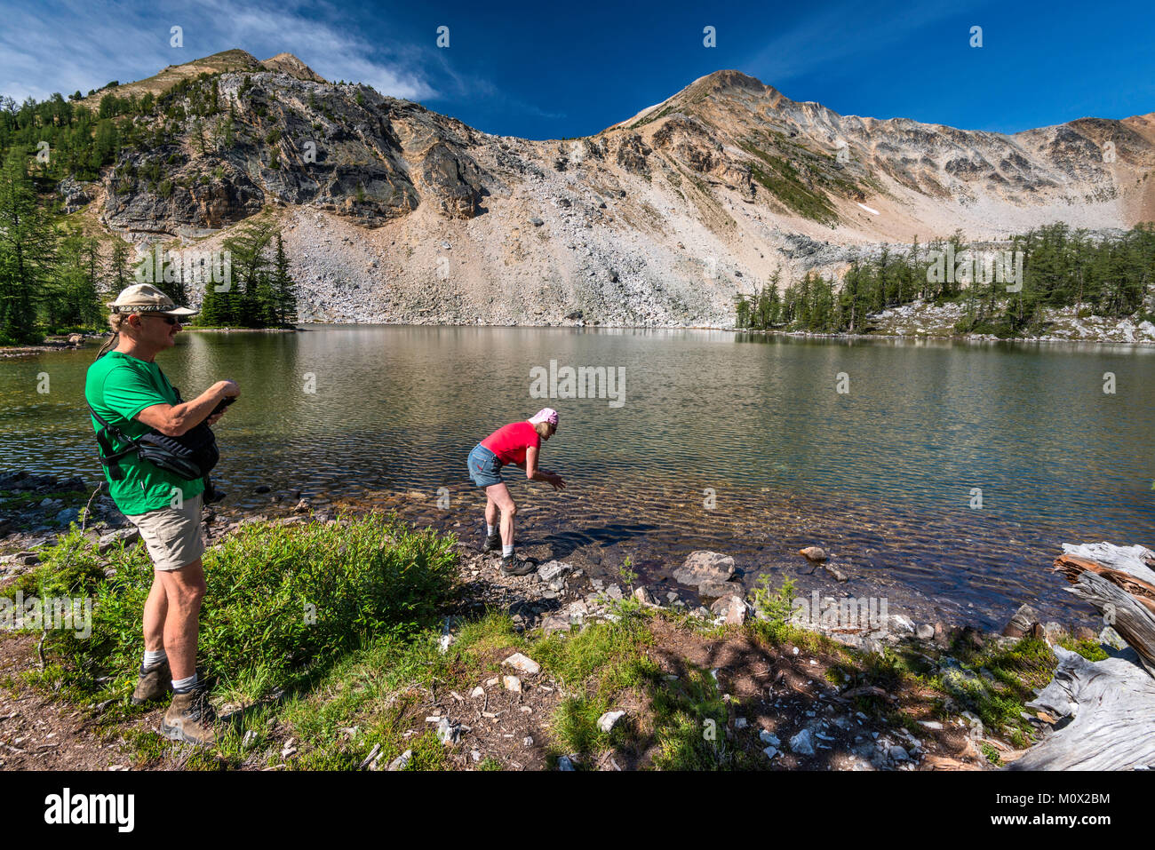 Persone di mezza età gli escursionisti a minore Brewer Lago, Mount Brewer in distanza, Purcell montagne, Kootenay Rockies, vicino Invermere, British Columbia, Canada Foto Stock