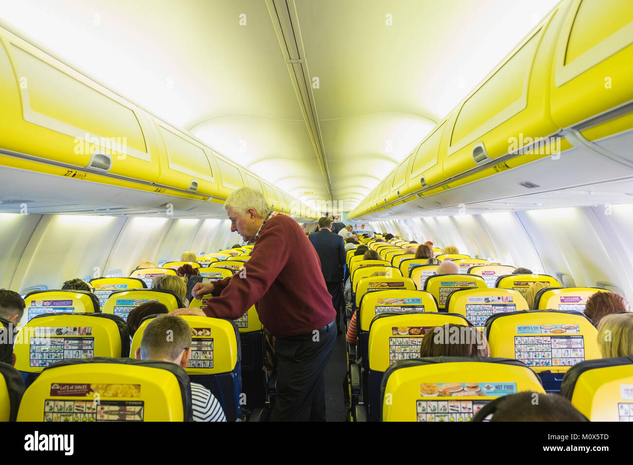 All'interno della cabina a bordo di un volo Ryanair passeggeri pasing tempo mentre si viaggia Foto Stock