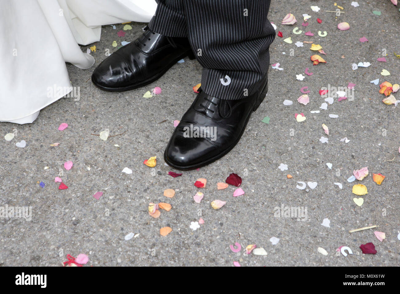 Dello sposo scarpe nero circondato da coriandoli a seguito di un matrimonio in Inghilterra. Foto Stock