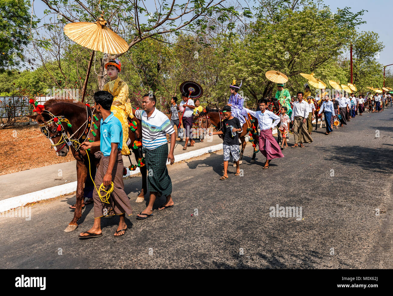 Ragazzi piccoli vestiti come principessa e andare in giro pagode durante la cerimonia Novication, Myanmar Foto Stock