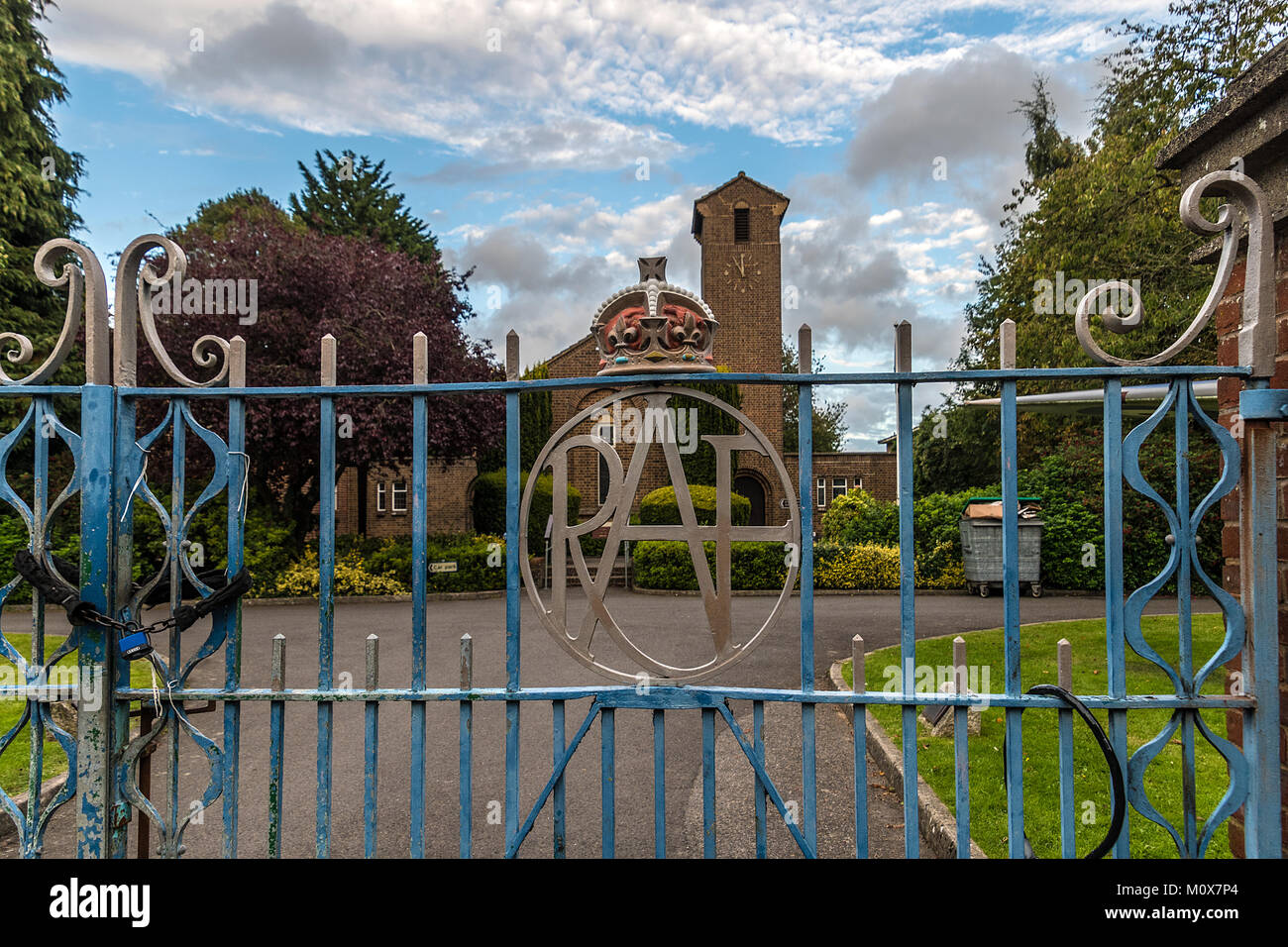 Cancelli a Biggin Hill, famoso WW2 RAF fighter vicino stazione di Bromley Kent. Vecchio ferro battuto con logo RAF e l'edificio amministrativo in background Foto Stock