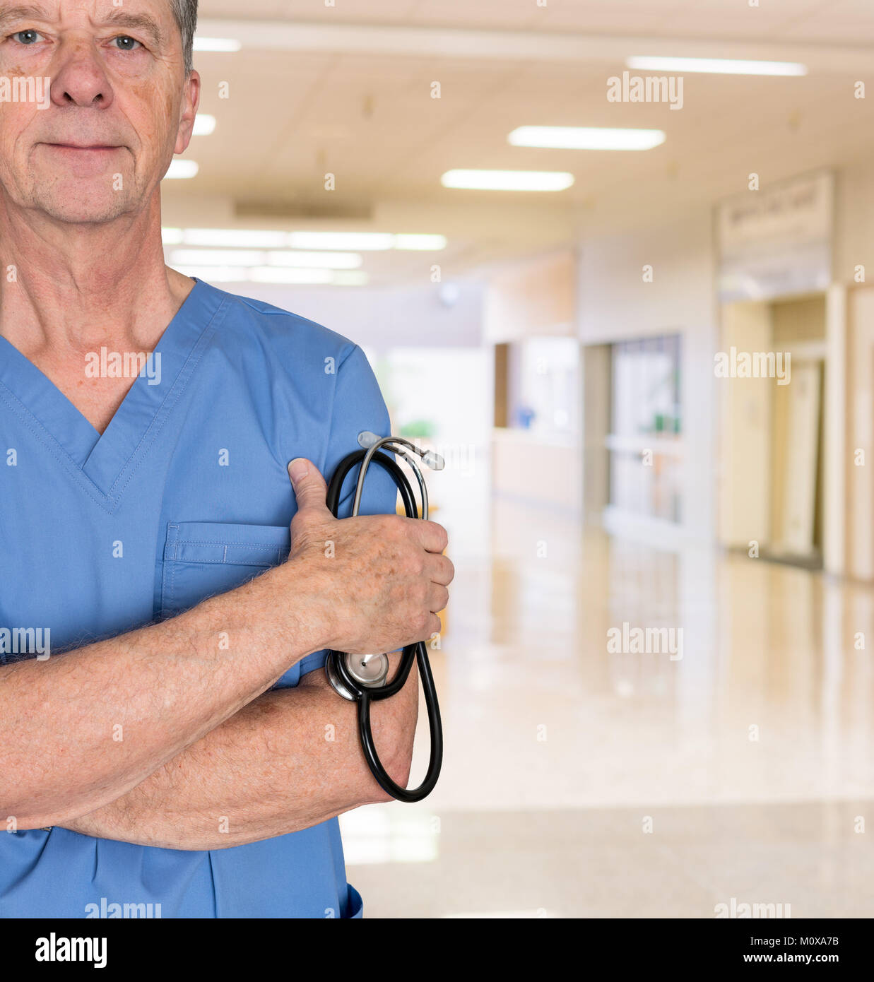 Senior consulente medico in blu scrubs Foto Stock