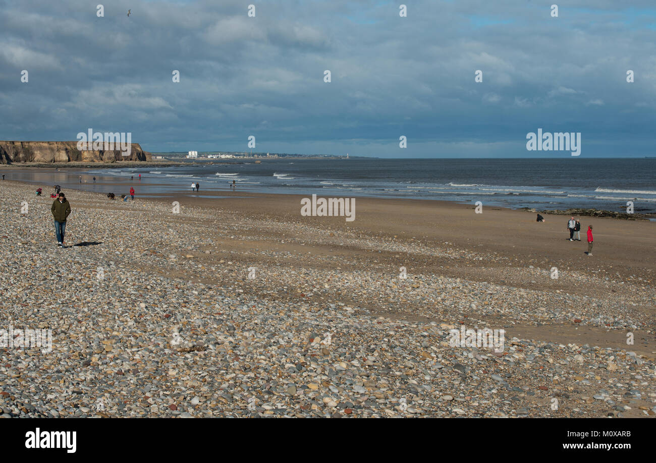 Seaham spiaggia guardando a nord con la città di Sunderland in lontananza sfondo e poche persone sulla spiaggia Foto Stock