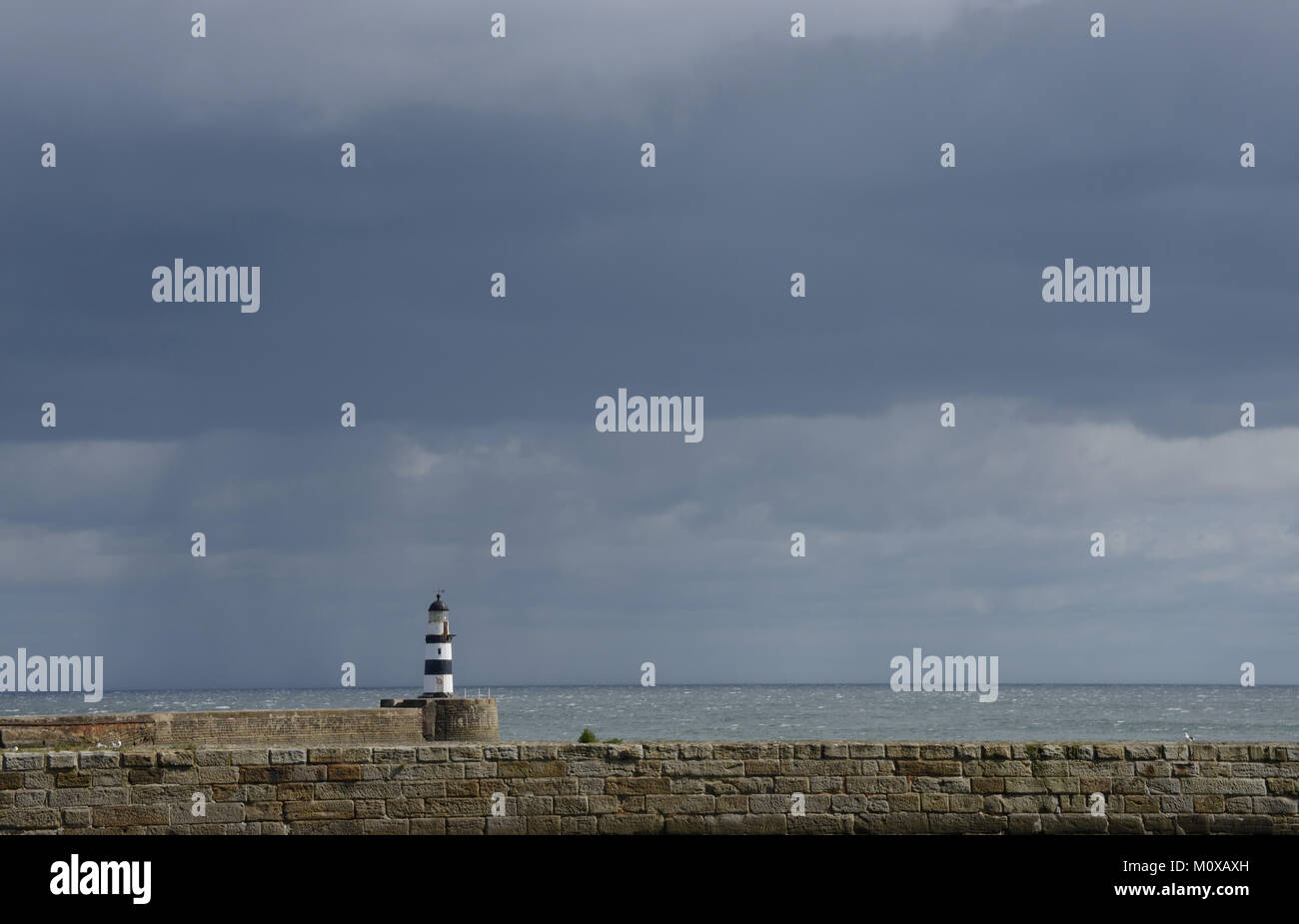 Il faro di Seaham Harbour contro un cielo scuro sulla costa nord-orientale del Regno Unito Foto Stock