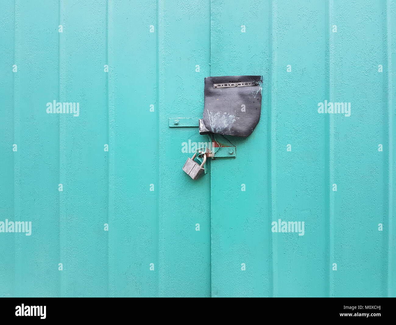 Grunge texture porte di metallo con nervature trasversali di acqua di mare colore, chiuso per una grande annata serratura. Foto Stock