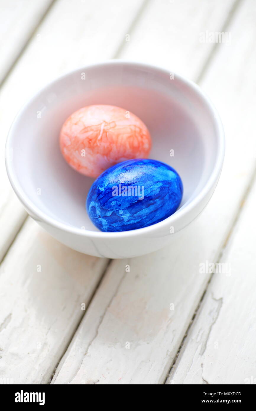 Due dipinti di uova di Pasqua in ciotola bianco Foto Stock