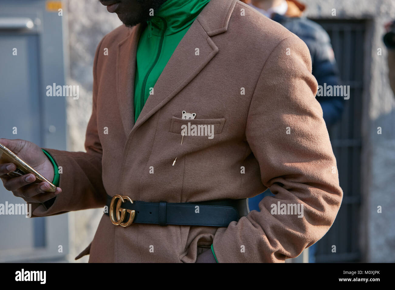 Milano - 13 gennaio: Uomo con rivestimento di colore marrone e nastro gucci guardando smartphone prima di Emporio Armani fashion show, la Settimana della Moda Milanese street style su Ja Foto Stock
