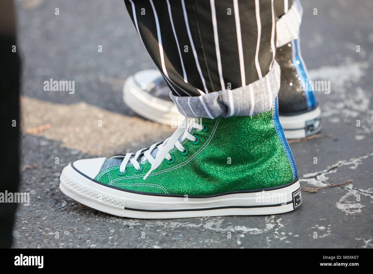 Milano - 13 gennaio: l'uomo con green Converse tutte le stelle glitter  sneakers e a strisce bianche e nere prima di pantaloni Diesel oro nero  fashion show, Mil Foto stock - Alamy