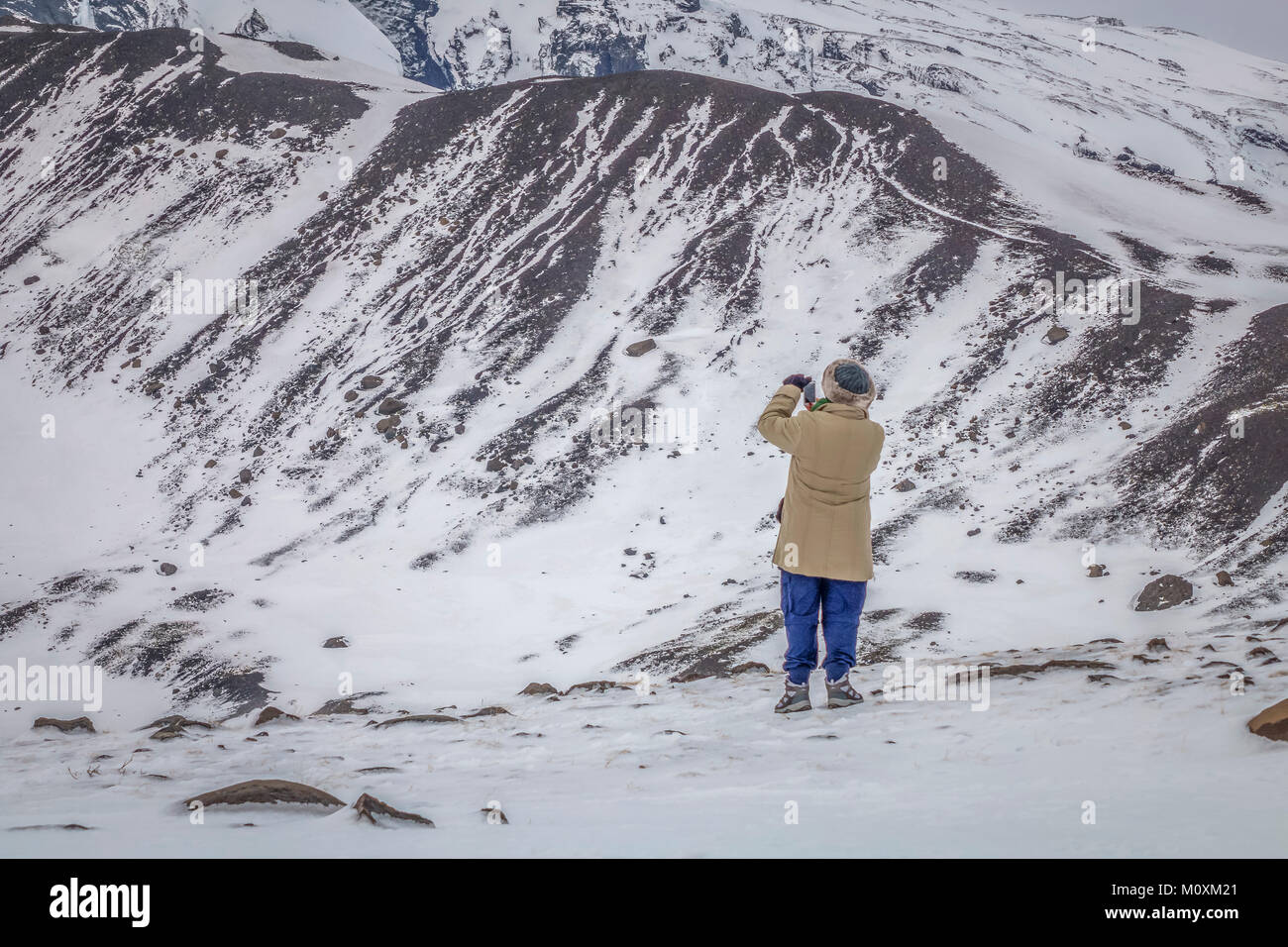 Turistica prendendo immagini dal ghiacciaio Gigjokull, inverno, Islanda Foto Stock