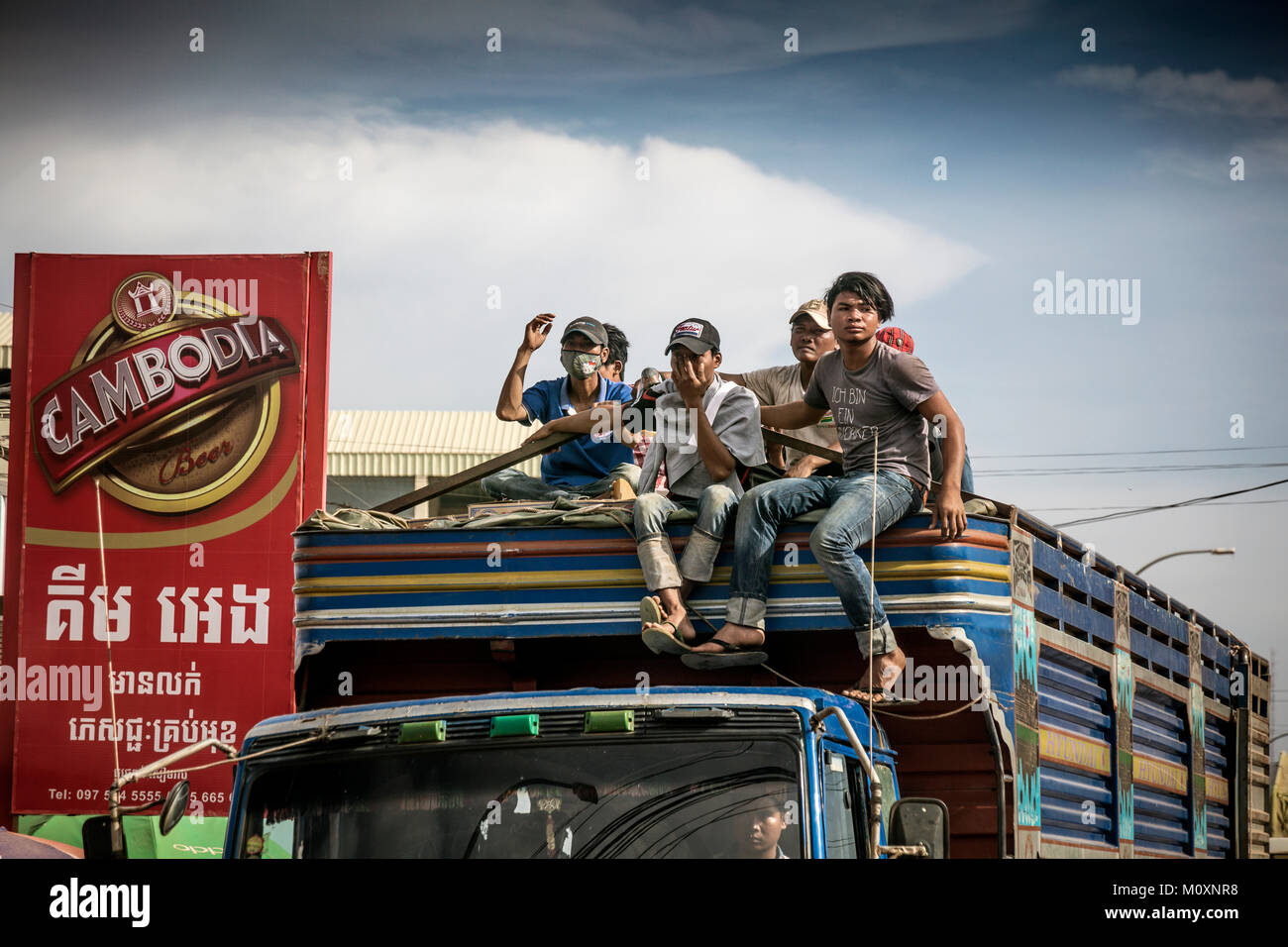 I cambogiani a cavallo sul tetto del camion, Sangkat Kouk Chat, Krong Siem Reap, Cambogia. Foto Stock