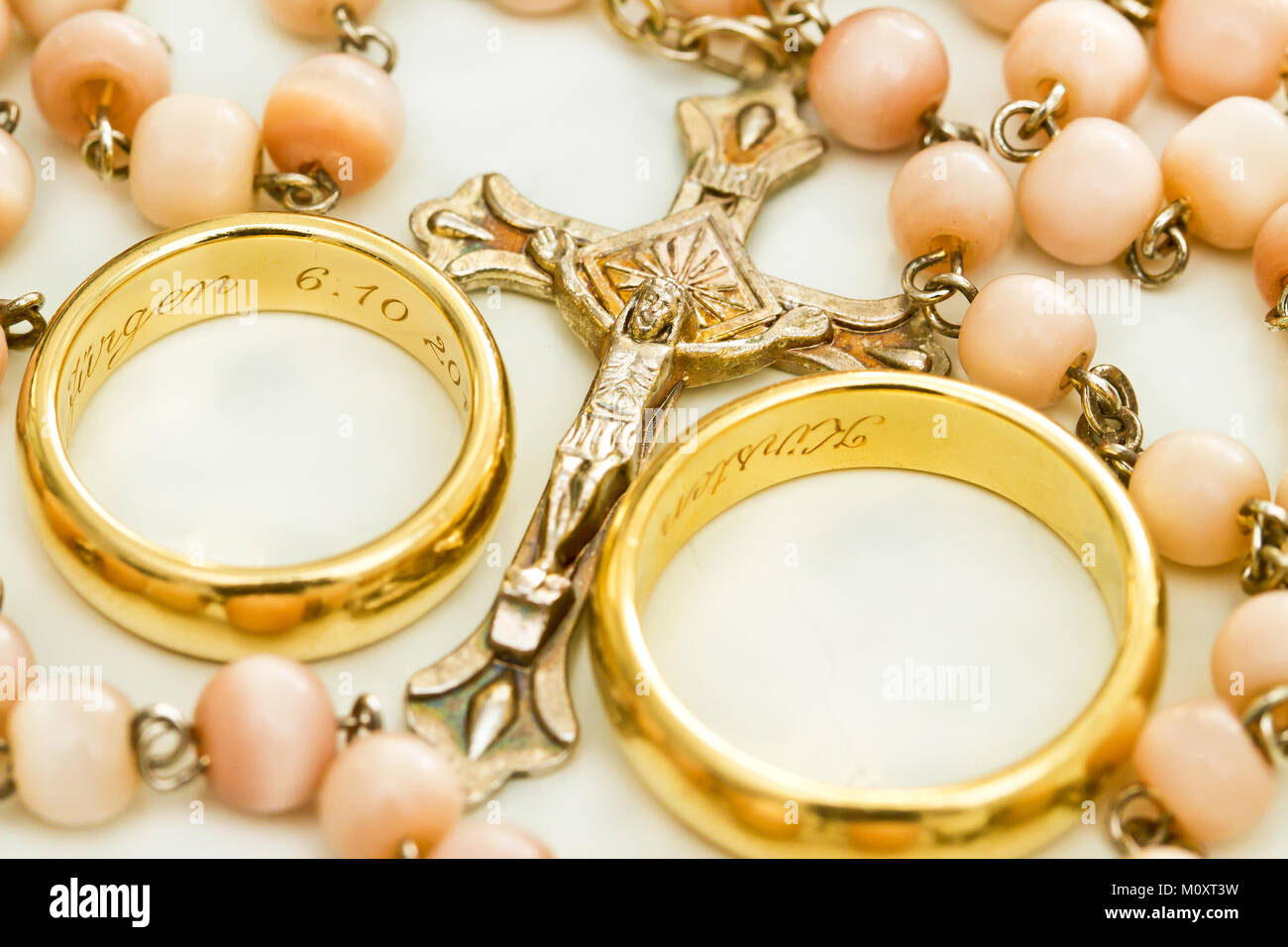 Due anelli di nozze e collana con crocifisso Foto Stock