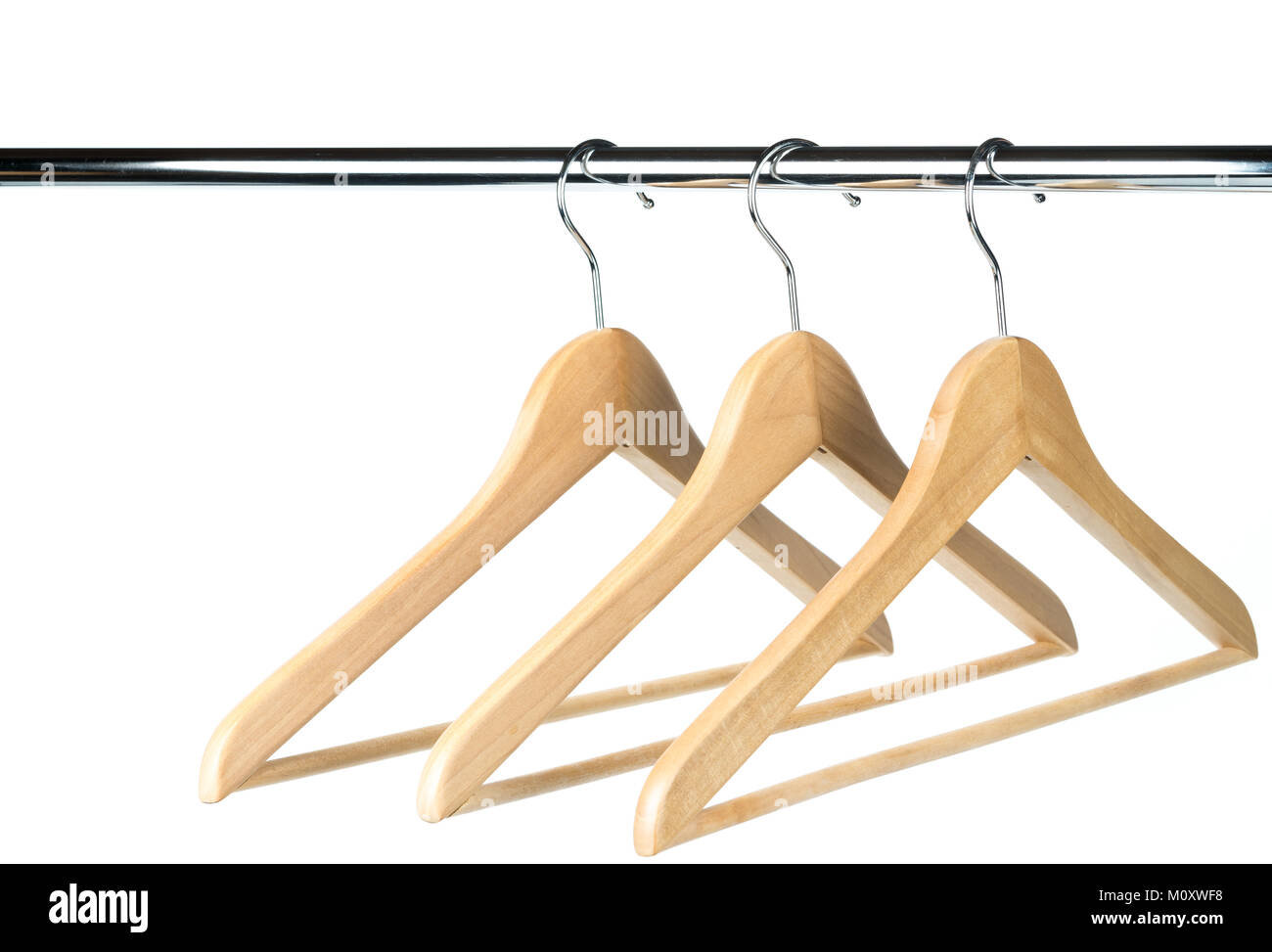 Tre vuoti di rivestimento in legno / appendiabiti su un bastone appendiabiti con uno sfondo bianco. Copia di potenziale spazio al di sopra e a sinistra del portabiti. Foto Stock