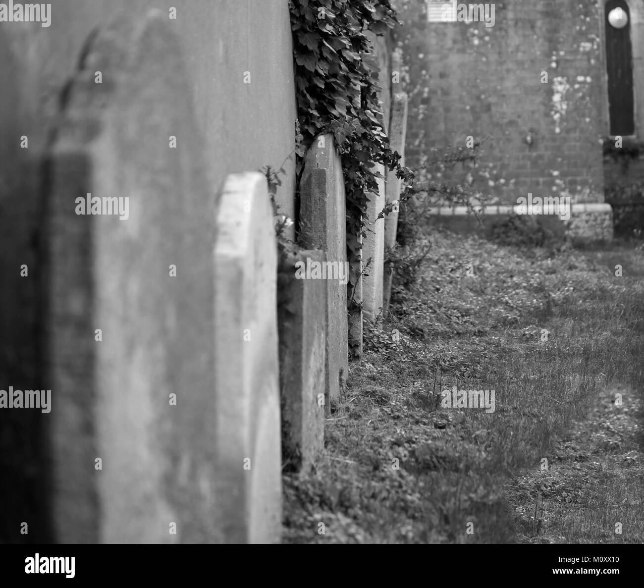 Lapidi appoggiata contro la parete della chiesa, Dorset Foto Stock