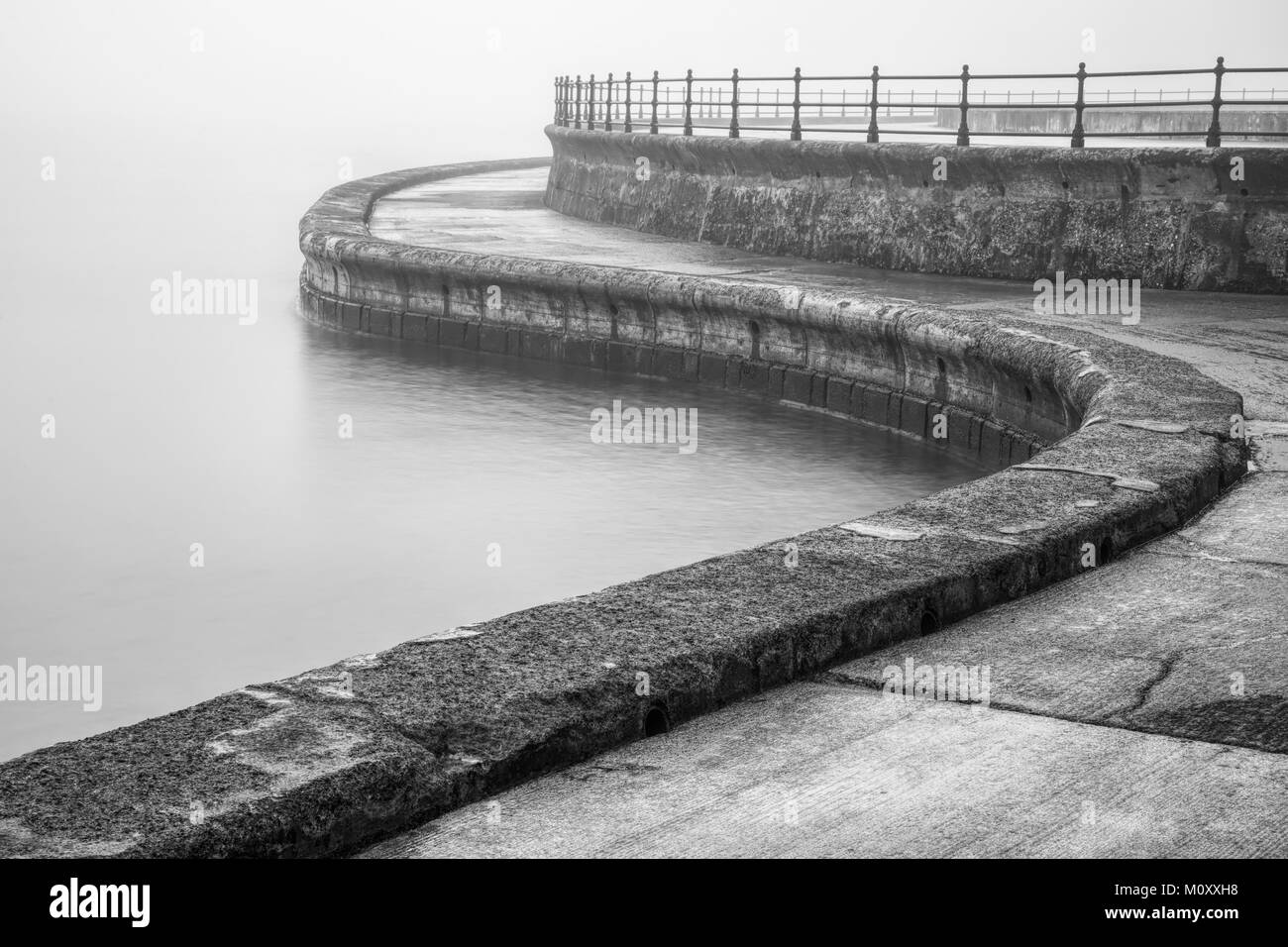 La passeggiata di fronte al mare a Scarborough sul bagnato giornata noiosa. Foto Stock