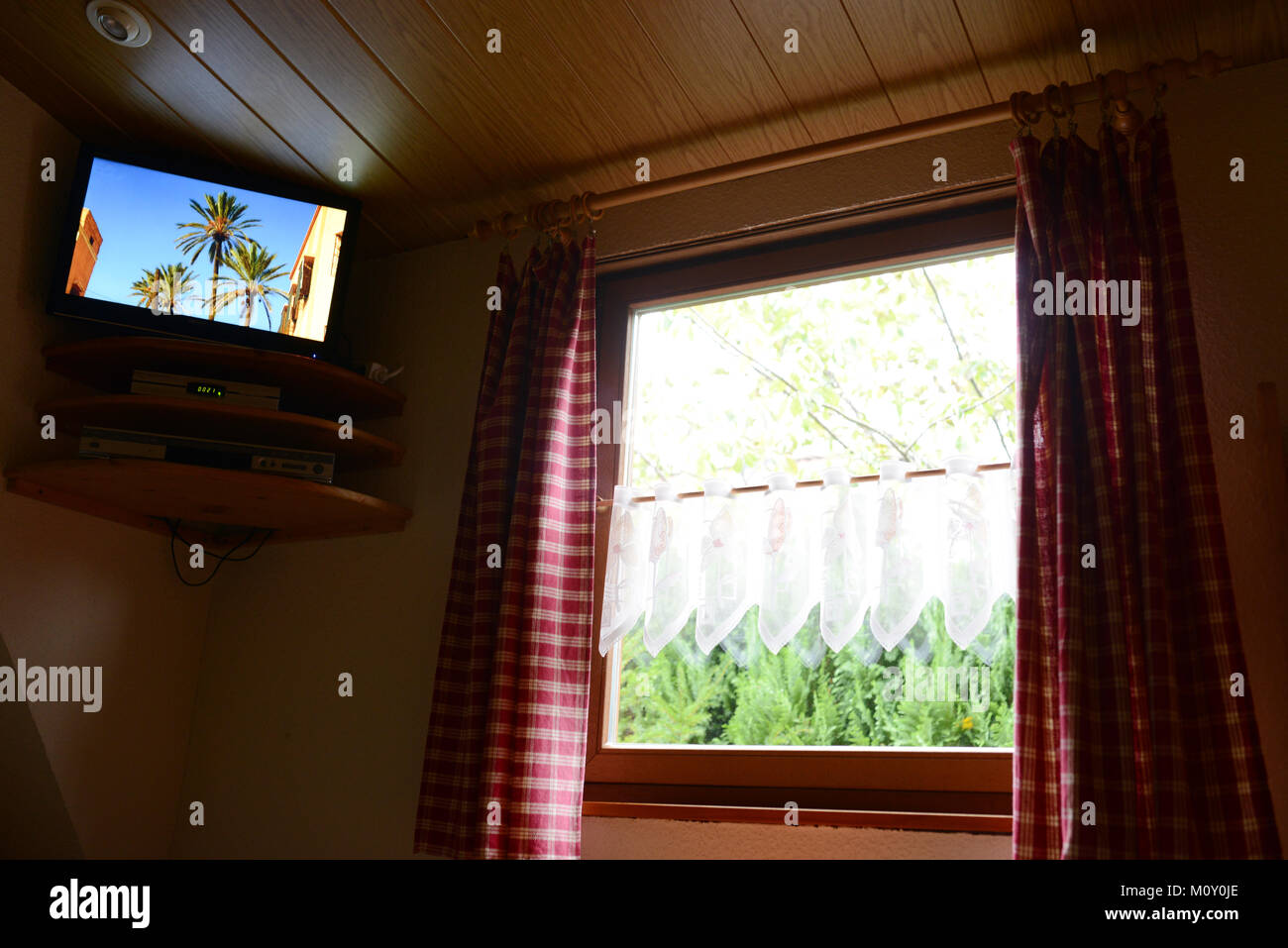 Televisore e la vista dalla finestra con tende rosse Foto Stock