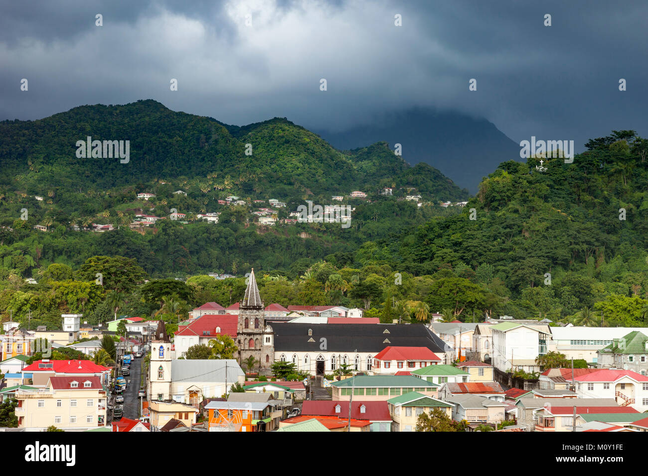 La luce del sole di scalda la città di Roseau sotto il cielo tempestoso, Dominica, Isole Sottovento, West Indies Foto Stock