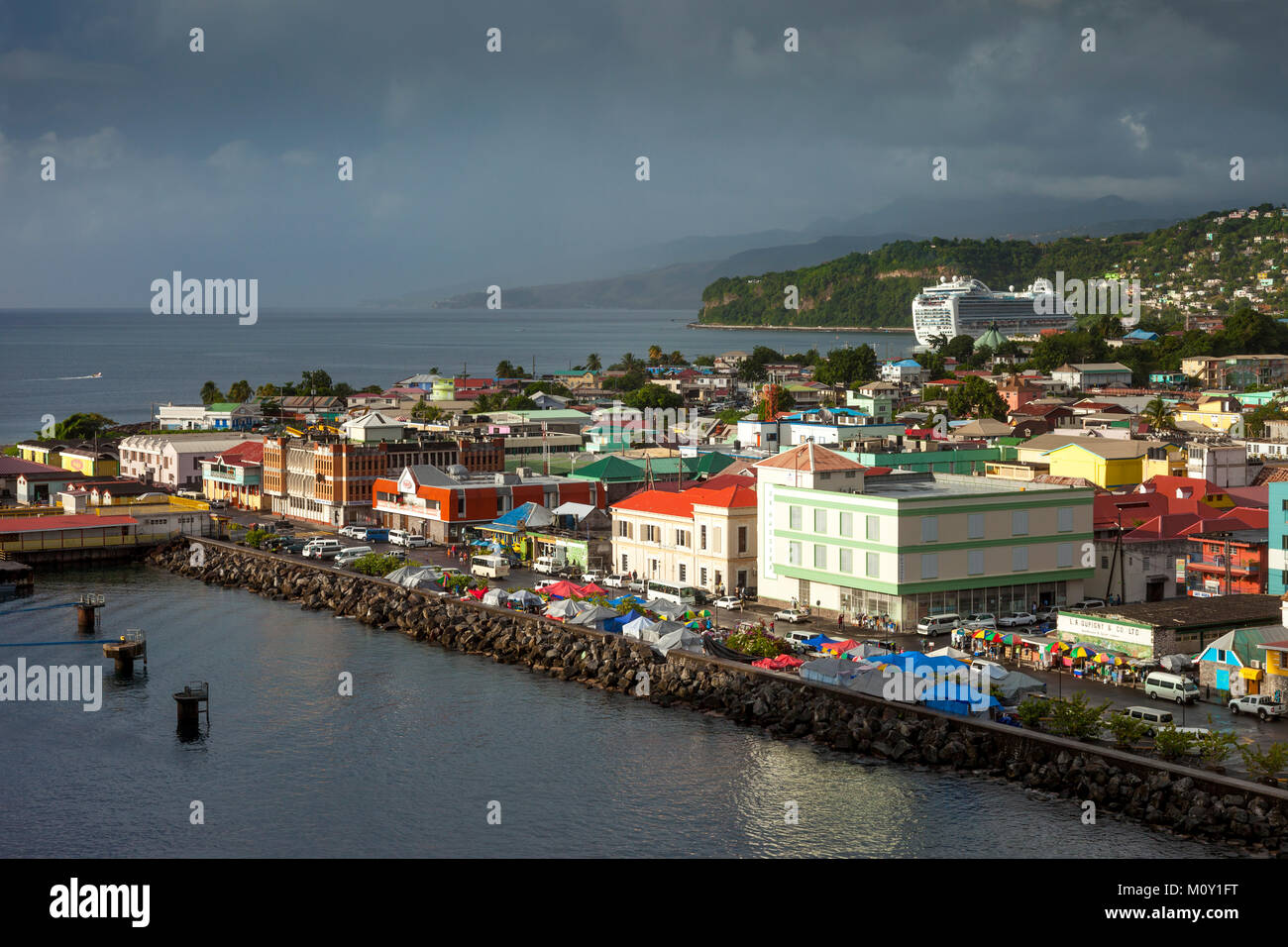 Gli edifici colorati linea il pontile di Roseau sotto il cielo tempestoso, Dominica, Isole Sottovento, West Indies Foto Stock
